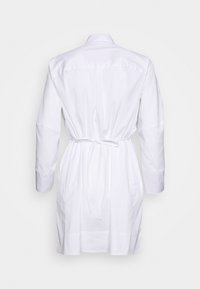 Weißes Baumwollhemdkleid mit Kragen, langen Ärmeln und Taillierung. Glatte Textur mit sichtbaren Nähdetails, knielanges Design.