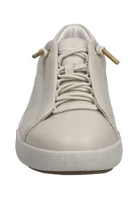 Zapatilla beige clara con parte superior de cuero suave, que presenta una suela de goma texturizada, cordones elásticos y ojales en tono dorado.