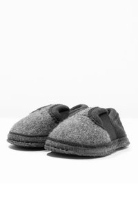Grijze wollen slippers met elastische zijkanten, ronde neus en gestikte details. Zachte textuur met een viltachtige afwerking. Platte zool voor comfort.