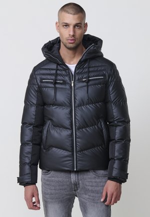 Chaqueta acolchada negra con capucha, con cierre de cremallera en la parte delantera, dos bolsillos en el pecho y puños de canalé, hecha de material brillante y acolchado.