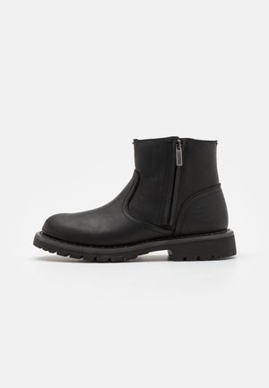 Schwarze Leder-Ankle-Boots mit abgerundeter Spitze, seitlichem Reißverschluss, Gummisohle und strukturiertem Finish. Auf der Seite mit markenspezifischer Verzierung.