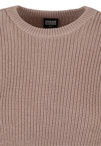 Lys rosa strikkegenser med rund hals. Teksturert ribbestrikkedesign, med en etikett inni som sier "Urban Classics, XS."