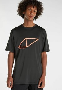 Mustapaita, joka on valmistettu kevyestä kankaasta, jossa on suuri oranssi geometrinen logo edessä ja lyhyet hihat.