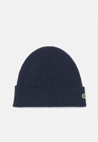 Căciulă tricotată neagră cu nervuri, cu margine pliată și accent de logo verde, material texturat care oferă elasticitate și căldură.