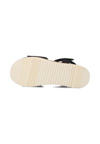 Zwarte sandaal met een gestructureerde, beige rubberen zool met horizontale groeven voor grip. De banden zijn gemaakt van zacht stofmateriaal.