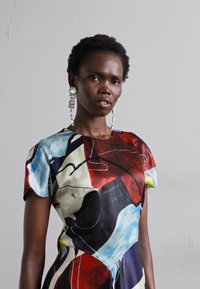 Rochie abstractă, multicoloră, cu mâneci scurte, având nuanțe vibrante de roșu, albastru și negru. Material neted, lucios, cu o siluetă ajustată.