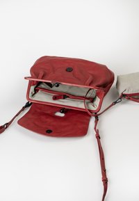 Borsa a spalla in pelle rossa con una texture morbida, chiusura a pattina, bottoni neri e interno in tessuto a righe. Include una tracolla regolabile.