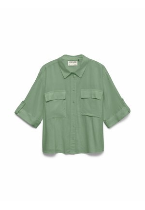 Lichtgroen overhemd met knopen, twee klepzakken aan de voorkant en opgerolde driekwart mouwen.