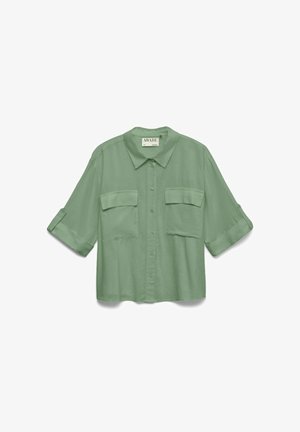 Lichtgroen overhemd met knopen, twee klepzakken aan de voorkant en opgerolde driekwart mouwen.