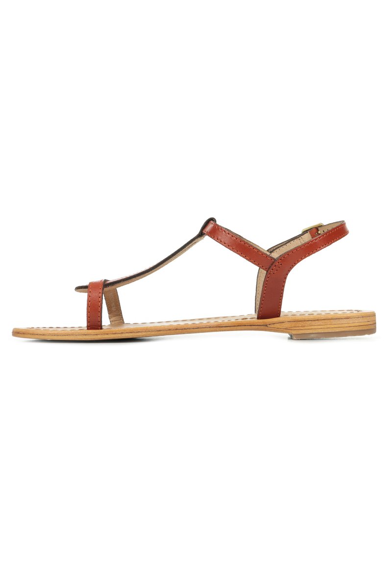 Bruine leren sandaal met een minimalistisch ontwerp, open teen, T-strop, gespsluiting en een platte houten zool met een textuurpatroon.