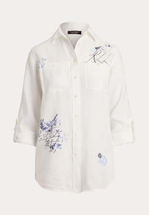 White linen shirt with blue ink splatter designs, two front pockets, buttoned cuffs, and a classic collar. Features decorative stitching.