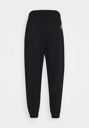 Zwarte joggingsbroek met een elastische tailleband, taps toelopende boorden en een klein logo op de achterzak. Zachte stof met een gladde textuur.