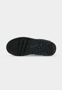 Μαύρη σόλα παπουτσιού Nike με σχέδιο πέλματος που περιλαμβάνει τετράγωνα και ορθογώνια σχήματα και ορατό λογότυπο Nike στο κέντρο.
