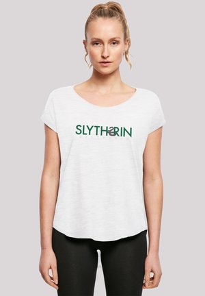 Hvitt kortermet t-skjorte med løs passform, med en grønn "SLYTHERIN" tekstlogo over fronten. Mykt, lett stoff.