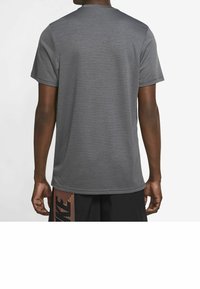 Grå atletisk t-shirt med rund halsringning, korta ärmar och en slät textur. Har ett subtilt melerat mönster i tyget.