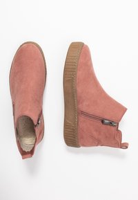 Un par de botas de ante rosas hasta el tobillo con cremalleras laterales, suelas texturizadas marrones y forro de forro polar, mostradas desde vistas superior y lateral sobre fondo blanco.