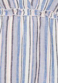 Tissu rayé avec des lignes verticales bleues, roses, blanches et noires, présentant une couture élastique froncée au centre.