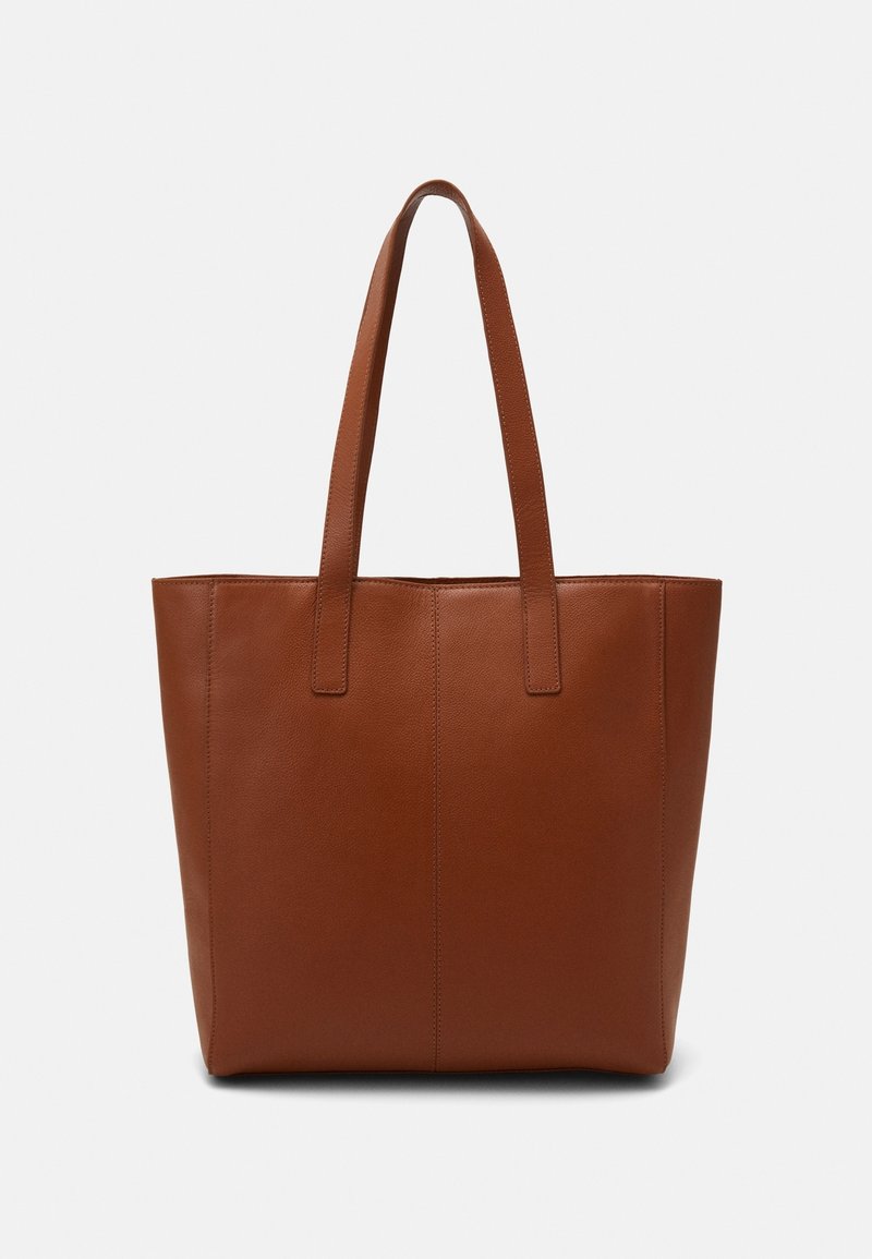 Sac cabas en cuir marron avec deux longues anses et un design simple et épuré sur un fond uni.