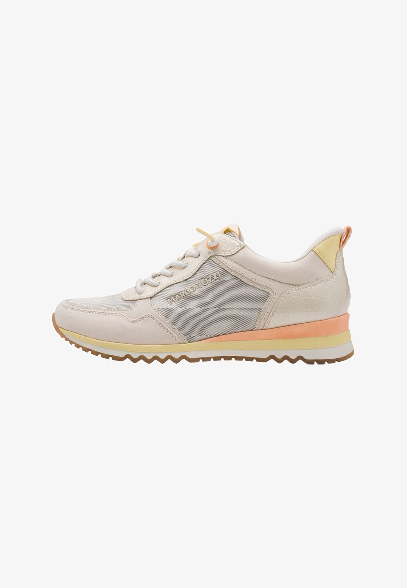 Baskets beige clair avec des panneaux en mesh et en daim, dotées d'une semelle blanche avec un accent orange et jaune. Lacets ronds et semelle à motifs zigzag.