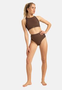 Braun zweiteiliger Badeanzug mit einem hochgeschnittenen Crop-Top mit floralen Akzenten und hochgeschnittenen Hosen; glatte Textur, minimalistisches Design.