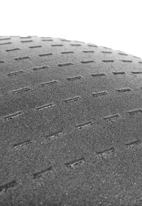 Schwarze, strukturierte Oberfläche mit kleinen, rechteckigen Vertiefungen. Das Material wirkt langlebig mit einer matten Oberfläche, die den Griff und die Stabilität erhöht.