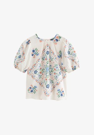 Blouse blanche à manches bouffantes ornée de motifs floraux bleus, verts et pêche disposés en losange central et en grappes dispersées.