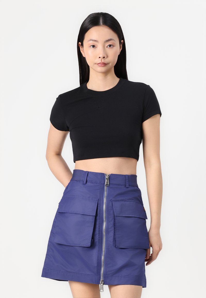 Black cropped t-shirt with short sleeves paired with a purple skirt featuring a front zipper and two large pockets. Smooth texture.
