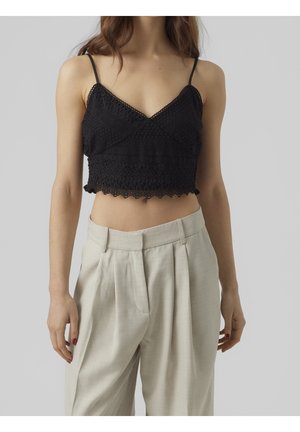 Sort, hæklede cropped top med tynde stropper, prydet med en bølget kant og struktureret design, kombineret med beige højtaljede bukser.