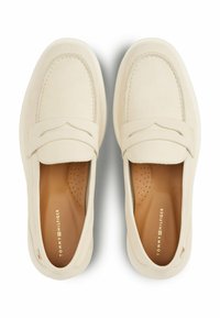 Beige slip-on loafers med en blød suede overdel, der har et syet design, perforeret inderside og diskret branding på indersålen.