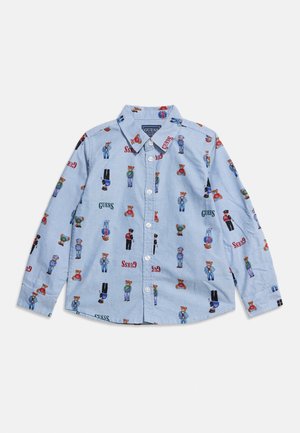 Világoskék, hosszú ujjú, gombos ing, amelyen sokszínű maci minták és "GUESS" feliratok találhatók a szöveten szétszórva.