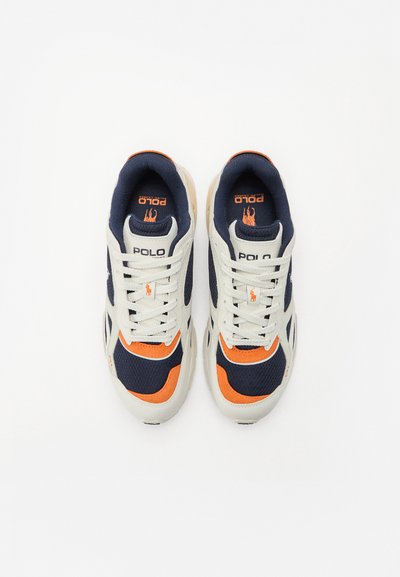 Sapatilhas em malha brancas e azul-marinho com detalhes em laranja. Apresentam um design com atacadores e sola de borracha. Marca "Polo" na língua e na lateral.