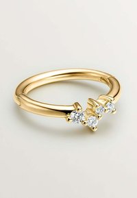 Anillo de oro con una banda lisa, tres piedras preciosas redondas y transparentes engastadas en un diseño de garras. Acabado elegante y pulido con acentos sutiles.