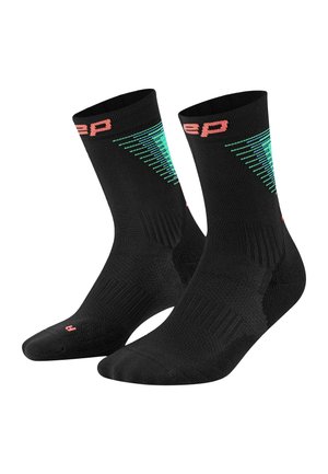 Black mid-calf athletic socks with green diagonal stripe pattern and pink lettering near the top and on the toe area, shown in a pair.