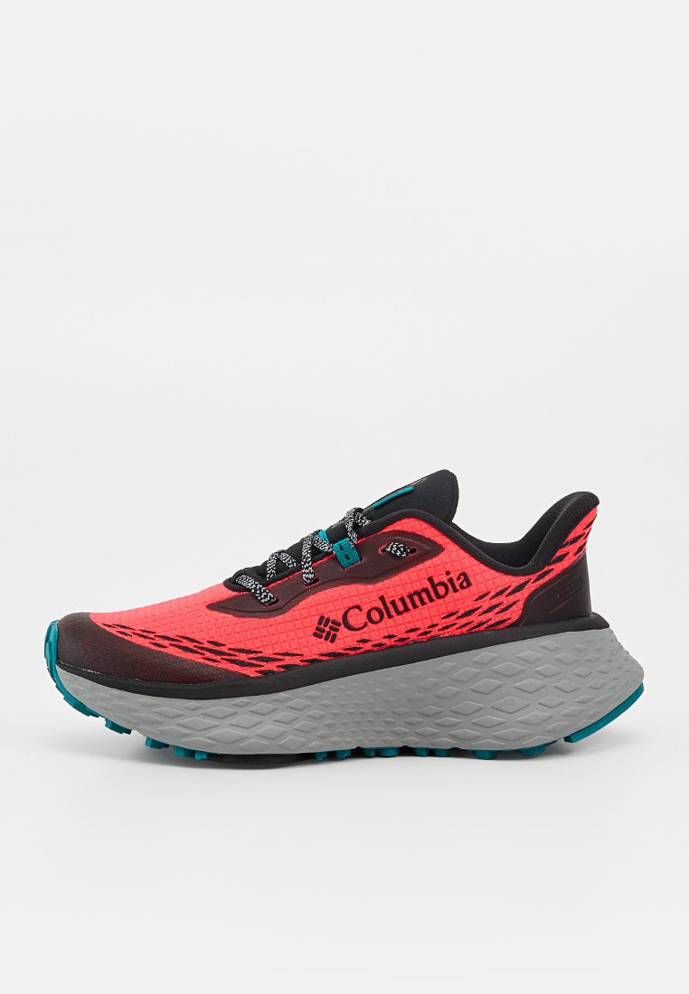 Zapatilla de correr Columbia roja y negra con suela gruesa gris, cordones en blanco y negro, y detalles en color verde azulado, vista desde el lado izquierdo sobre fondo blanco.