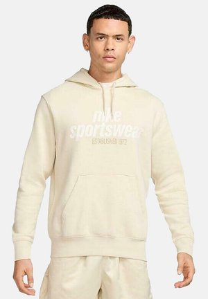 Beige hoodie met een voorzak en een trekkoordcapuchon. Grafische tekst "Nike Sportswear Established 1972" is op de borst gedrukt.