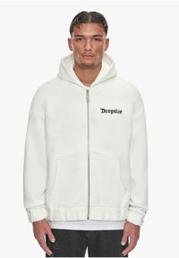 Biała hoodie na zamek, wykonana z miękkiego materiału; posiada przednią kieszeń, ściągacz u dołu oraz haftowane logo "Dropsize" w czerni na klatce piersiowej.