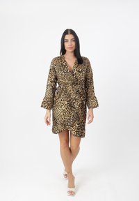 Vestido envolvente de estampado de leopardo con mangas largas, escote en V profundo y cintura ceñida con cinturón. Hecho de una tela suave con una textura lisa y un diseño fluido.