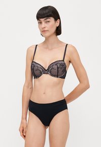 Zwarte kant bh met beugel en verstelbare banden, met bloemmotieven. Gepaarde met hoge taille zwarte slipjes, met een gladde textuur.