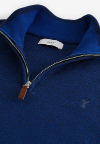 Marineblauer Reißverschluss-Pullover mit geripptem Kragen, silberner Reißverschluss und kleinem Logodetail. Weicher Stoff, lässiges Design, geeignet zum Layering.