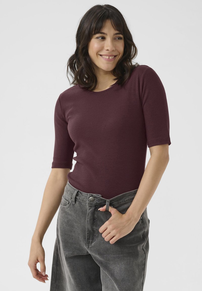Burgundy ribbed top with a crew neck and short sleeves, paired with high-waisted gray jeans featuring front pockets and a button closure.