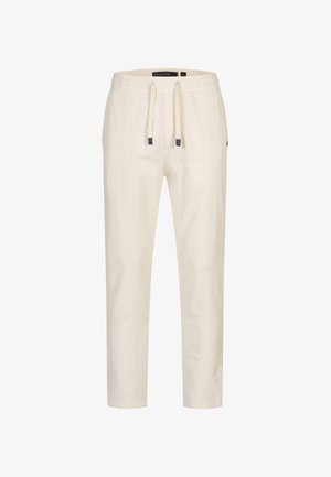 Lys beige joggebukser med en strukturert tekstilmønster, elastisk linning og en innsvingt design med sidelommer.