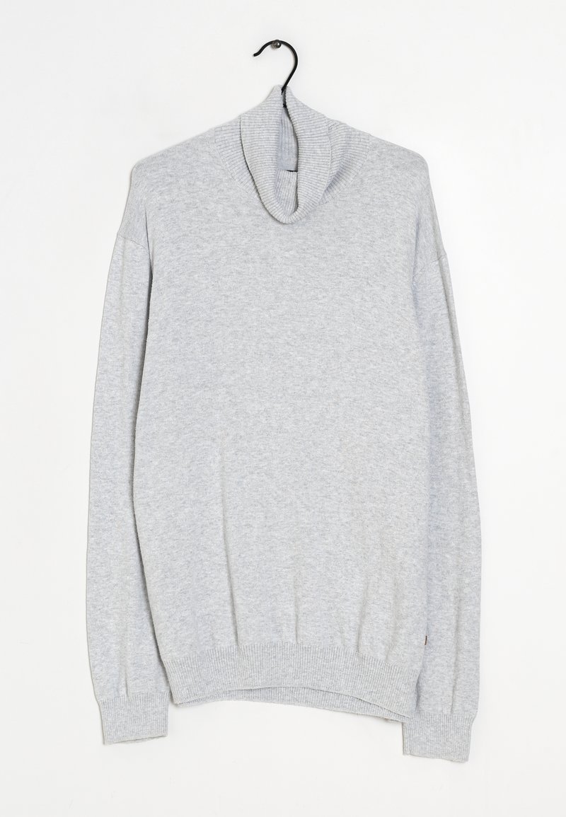 Maglione a collo alto grigio chiaro a maniche lunghe appeso a una gruccia nera su sfondo bianco.
