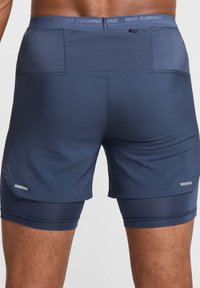 Pantalones cortos de running para hombre en azul oscuro con cintura texturizada, capa interior de compresión, acentos reflectantes y tejido que absorbe la humedad.