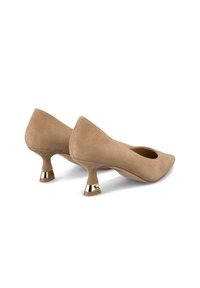 Décolleté in suede beige con punta affusolata e tacco moderato. Il tacco presenta un accento metallico alla base, aggiungendo un dettaglio distintivo.