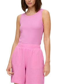 Roze mouwloos topje van zachte stof, gecombineerd met roze textuur shorts met een elastische tailleband. Beide zijn effen van kleur zonder patronen.