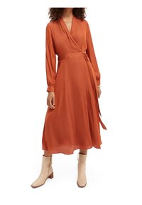 Ruskohvärviline ümbritseva kleit, millel on pikad varrukad, seotav vöökoht, voogav kangas ja keskmine pikkus. Koos beežide pahkluukohtade saabastega, millel on tekstuuriga disain.