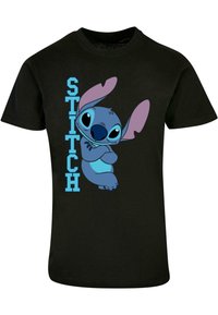 Zwarte katoenen T-shirt met een blauwe cartoonfiguur met grote oren en een speelse uitdrukking, naast de tekst "STITCH" in het blauw.