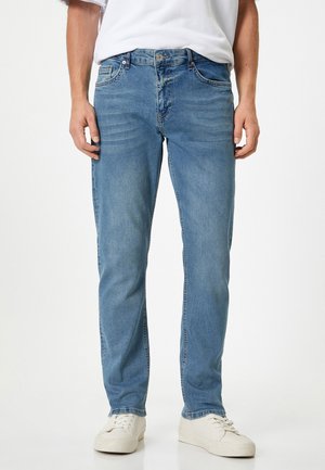 Jeans de mezclilla azul claro con corte recto, cinco bolsillos y cierre de botón. Textura suave con sutiles detalles de desvanecimiento.