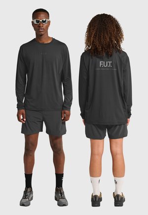 Sort sæt med langærmet skjorte og shorts i fugtafvisende stof, logo foran, bagpå er der teksten "F.U.T. PHYSICAL EDUCATION & TRAINING."