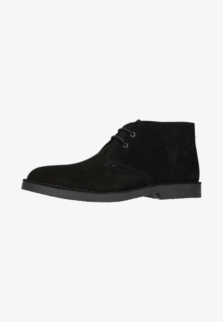 Bottines en suède noir avec une texture lisse, dotées de deux œillets pour les lacets et d'une semelle en caoutchouc plate. Design minimaliste avec un bout rond.